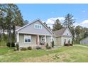 Charming two-story home with landscaped yard, front porch seating area, and craftsman-style architecture at 115 Mill Run Ln, Sanford, NC 27330