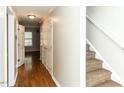 Hallway with hardwood floors leads to carpeted stairs with white trim at 116 Old Maple Ln, Durham, NC 27713