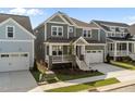 Lovely two-story home boasts a charming front porch, attached two-car garage, and well-kept lawn at 1245 Porters Call Dr, Wendell, NC 27591
