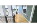 A cozy front porch with stone pillars, wood flooring, and calming atmosphere perfect for relaxing at 1245 Porters Call Dr, Wendell, NC 27591
