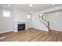 Bright, open living area with fireplace, wood floors, white trim, and stairway access to upper level at 1245 Porters Call Dr, Wendell, NC 27591
