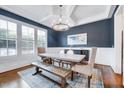 Dining room with coffered ceilings, modern chandelier, dark blue paint, and light wood floors at 1309 Pecora Ln, Raleigh, NC 27607