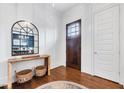 Bright foyer with wood floors, entry door, and large mirror over a console table with accent baskets below at 1309 Pecora Ln, Raleigh, NC 27607