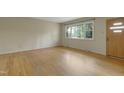 Open living room with hardwood floors, a large window, and a front door, creating a welcoming space at 208 Clark Lake Rd, Durham, NC 27707