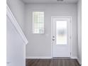 Bright entryway with wood-look floors, staircase, and a sidelight window near the front door at 2122 Willow Gln Dr, Graham, NC 27253