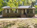 Olive green siding adorns this home, complemented by brick accents and crisp white trim at 216 Burkwood Ln, Raleigh, NC 27609