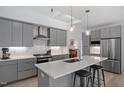 Contemporary kitchen featuring gray cabinets, stainless steel appliances, a center island with seating, and lots of lighting at 2225 Millbank Village Ct # 101, Raleigh, NC 27610
