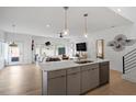 Open-concept kitchen and living area with stainless steel appliances, pendant lighting, and access to the exterior at 2225 Millbank Village Ct # 101, Raleigh, NC 27610