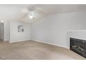 Spacious living room with a cozy fireplace, neutral carpet, and bright white walls showcasing an open floor plan at 2411 Vancastle Way # 202, Raleigh, NC 27617