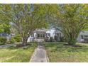 Charming home with a brick facade, inviting front porch, and mature trees in a well-manicured lawn at 2522 N Roxboro St, Durham, NC 27704