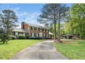 Traditional two-story brick home with a long driveway and mature trees at 254 Pine Forest Dr, Siler City, NC 27344
