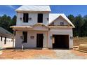 Image of a new two-story house construction with a garage and visible framing under a clear sky with trees in the background at 322 Bluejay St, Clayton, NC 27520