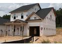 New two-story home featuring an attached garage and covered entryway with decorative brick columns at 322 Bluejay St, Clayton, NC 27520