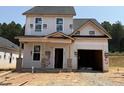 Under-construction two-story home with garage and covered entry, pre-drywall, nestled in a serene wooded area at 322 Bluejay St, Clayton, NC 27520