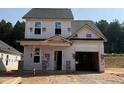 Two-story home with an attached garage in the beginning stages of construction with a large front yard at 322 Bluejay St, Clayton, NC 27520