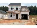 New construction two-story home featuring an attached garage and a partially covered front porch at 322 Bluejay St, Clayton, NC 27520