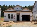 Exterior view of a home under construction with a garage and a yard with building materials at 330 Bluejay St, Clayton, NC 27520