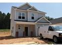 New two-story home boasts light gray siding, a covered front porch with brick and wood supports, and a contemporary design at 338 Bluejay St, Clayton, NC 27520
