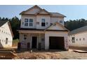 Two-story home showcasing the initial construction phase, featuring a garage and unfinished exterior elements at 338 Bluejay St, Clayton, NC 27520