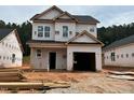 Two-story home with an attached garage under construction featuring newly installed windows and a dark roof at 338 Bluejay St, Clayton, NC 27520