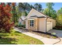 A beige house with stone accents, a well-kept lawn, and a side-entry garage at 4290 Sustain Cir, Franklinton, NC 27525