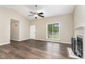 Bright living room with wood-look flooring, a fireplace, and a large window at 508 Baygall Rd, Holly Springs, NC 27540