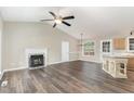 Spacious living room featuring a fireplace, ceiling fan, and wood-look flooring at 508 Baygall Rd, Holly Springs, NC 27540