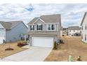 Charming two-story home showcasing a two-car garage, gray siding, and well-maintained yard at 512 Oak Holly Ln, Zebulon, NC 27597