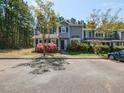 Inviting exterior of a gray townhouse showcasing charming curb appeal with mature trees and manicured landscaping at 519 Touchstone Dr, Durham, NC 27713