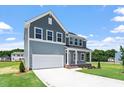 Beautifully landscaped two-story home with gray siding, a spacious garage, and a manicured lawn at 54 Grove Township Way, Angier, NC 27501