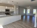 Bright, modern kitchen with stainless steel appliances, granite counters, and hardwood floors at 54 Grove Township Way, Angier, NC 27501