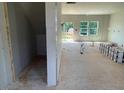Bright living room showcasing large windows and unfinished flooring, ready for customization at 54 Grove Township Way, Angier, NC 27501