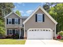 Inviting two-story home with a two-car garage and well-maintained front yard landscaping at 5413 Botany Bay Dr, Raleigh, NC 27616