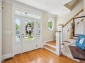 Bright foyer with hardwood floors, a staircase, and a view of the front door with sidelights at 5708 Butter Churn Way, Fuquay Varina, NC 27526