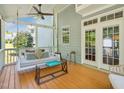 Relaxing screened porch featuring a porch swing, fan, and comfortable seating, ideal for outdoor lounging at 5708 Butter Churn Way, Fuquay Varina, NC 27526