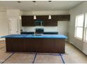Modern kitchen with dark cabinets, stainless steel appliances, and a large island at 59 Grove Township Way, Angier, NC 27501