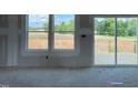 Bright living room featuring large windows and sliding glass doors leading to an outdoor deck at 59 Grove Township Way, Angier, NC 27501