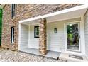Inviting front porch with stone column detail and a gray painted entryway at 6409 Lakeland Dr, Raleigh, NC 27612