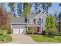 Two-story home featuring a red front door, well-manicured lawn and a two-car garage at 709 Basil Dr, Durham, NC 27713