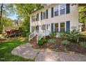 Close-up of a charming home entrance with brick stairs, white railings, and inviting landscaping at 7433 Deer Track Dr, Raleigh, NC 27613
