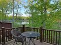 Relaxing outdoor deck overlooking a serene lake, surrounded by lush trees and a comfortable seating area at 8002 Upper Lake Dr, Raleigh, NC 27615