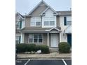 Charming two-story townhome featuring neutral siding, green shrubbery and well-lit entrance at 8013 River Water Ct, Raleigh, NC 27616