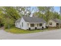 Charming single-story home featuring a covered front porch, black accents, and mature trees at 905 David St, Henderson, NC 27536