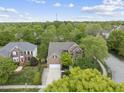 An aerial view of a brick home surrounded by mature trees and a well-maintained lawn at 9100 Dansforeshire Way, Wake Forest, NC 27587