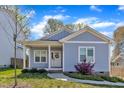 Charming blue single-Gathering home with a welcoming front porch and a well-manicured lawn, embodying curb appeal at 1008 Holloway St, Durham, NC 27701