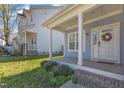 Inviting front porch with classic white columns and a lovely wreath on the front door, offering a warm welcome at 1008 Holloway St, Durham, NC 27701