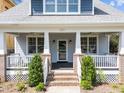 Inviting front porch with brick accents, white railings, and well-manicured landscaping at 1011 Parker St, Raleigh, NC 27607