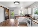 Charming kitchen with white cabinets, wood countertops, and a rustic barn door at 1017 Southerlund Rd, Garner, NC 27529
