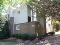Brick townhome featuring multiple windows, neutral siding, landscaped lawn, and a covered entrance at 1062 Washington St # 201, Raleigh, NC 27605