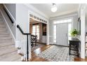 Bright foyer with staircase, hardwood floors, decorative rug, and view into the dining room at 10709 Thornbury Crest Ct, Raleigh, NC 27614